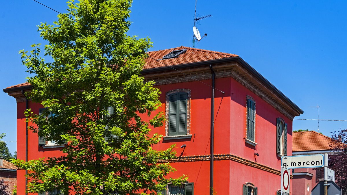 Casa rossa con giardino all’incrocio di via Marconi a Crespi d’Adda.