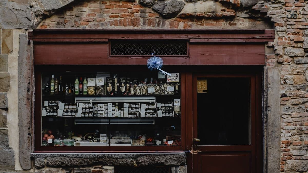 Vetrina di una bottega alimentare in una facciata in pietra e mattoni a Bergamo