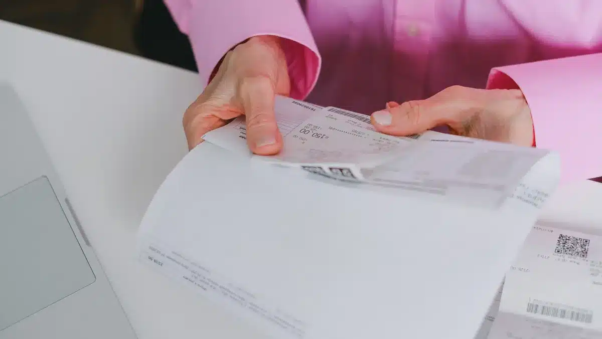 Una persona controlla ricevute e documenti su una scrivania