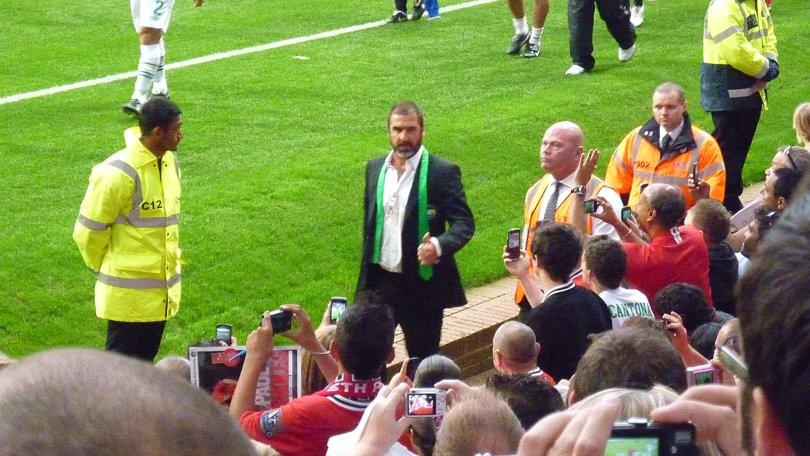 Eric Cantona a bordo campo circondato dai tifosi del Manchester United