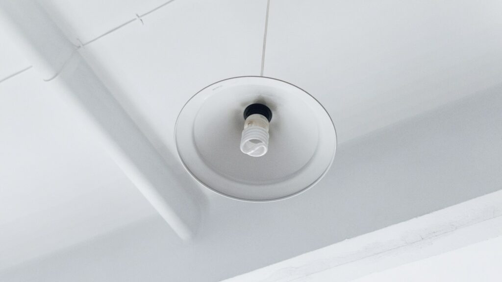 Lampadina fluorescente compatta in un paralume bianco