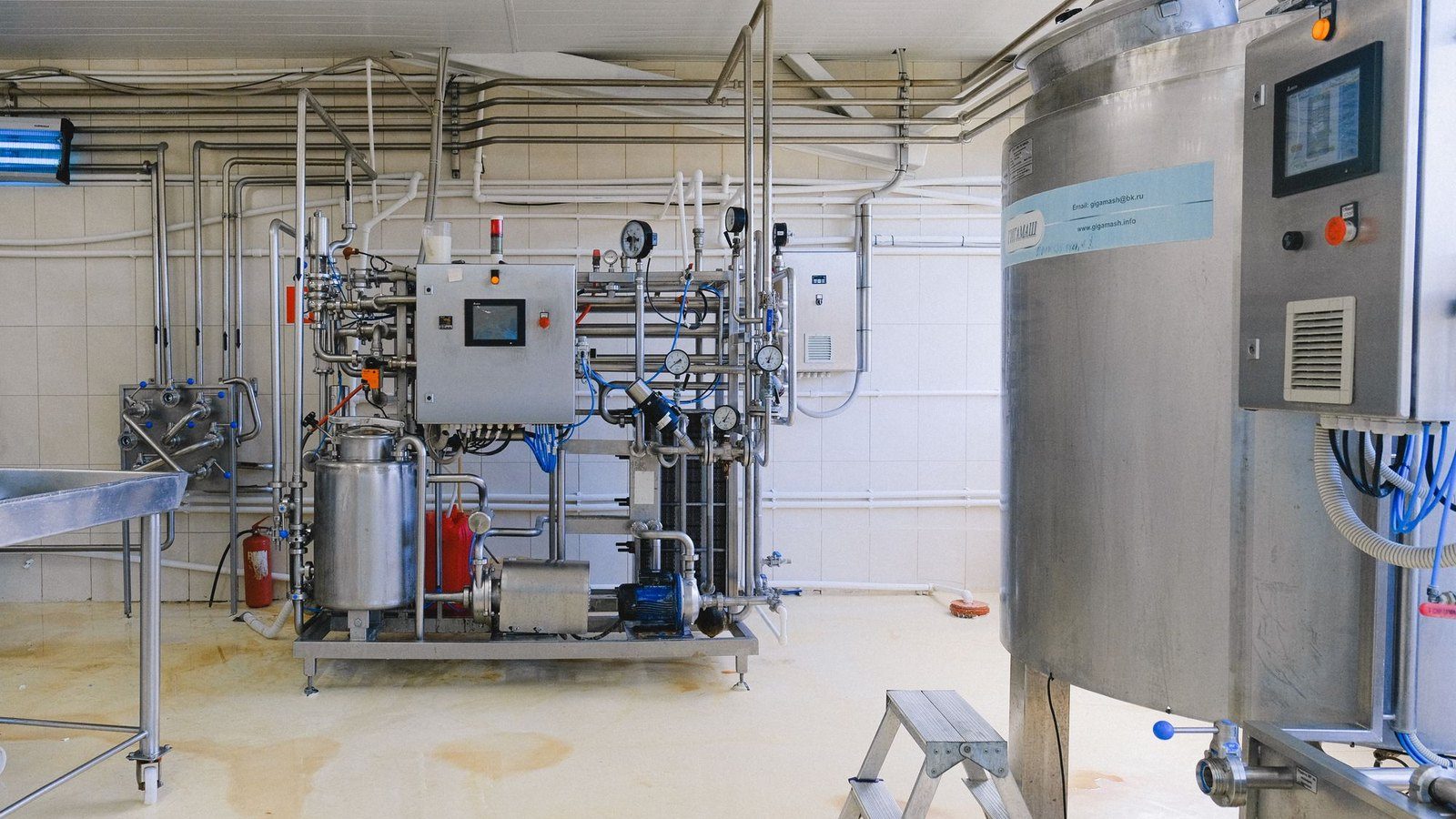 Serbatoi metallici, tubazioni e quadri di controllo in un impianto industriale