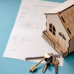 Modellino di una casa con chiavi e documento appoggiati sul tavolo