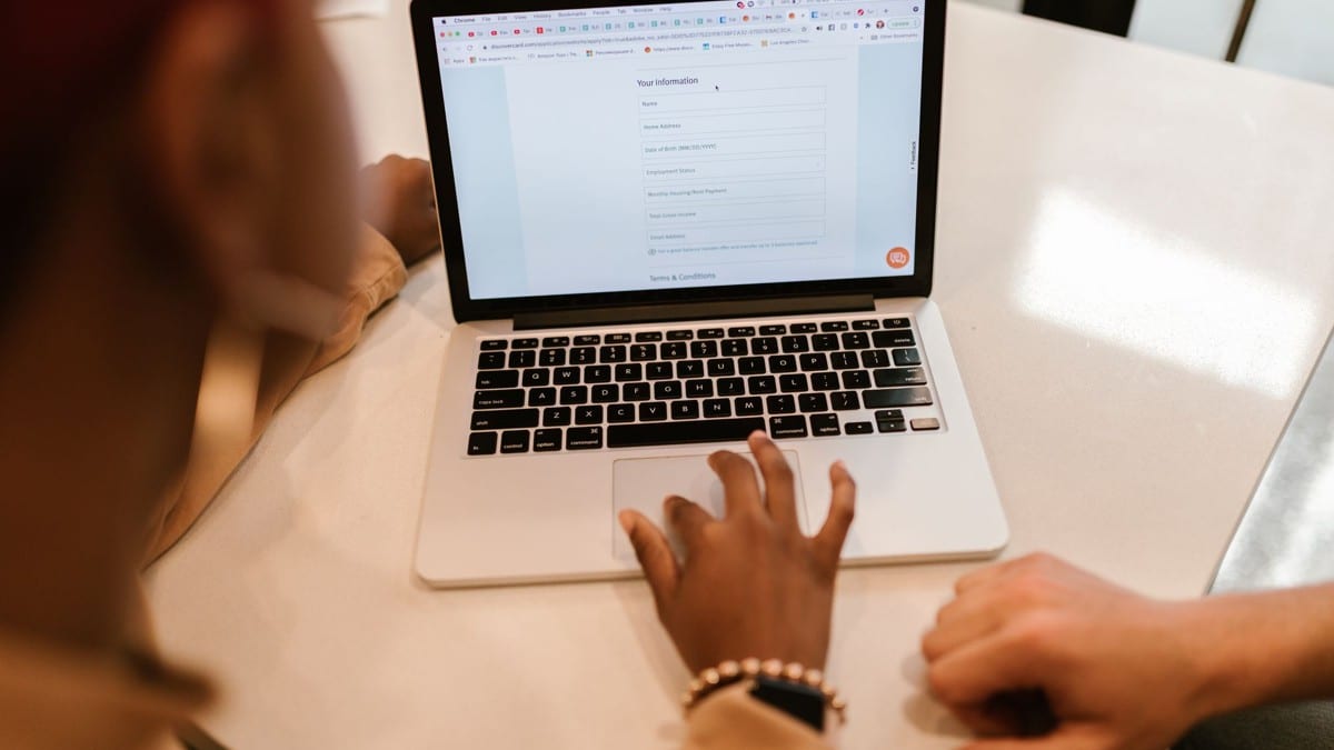 Due persone compilano un modulo online su un computer portatile.