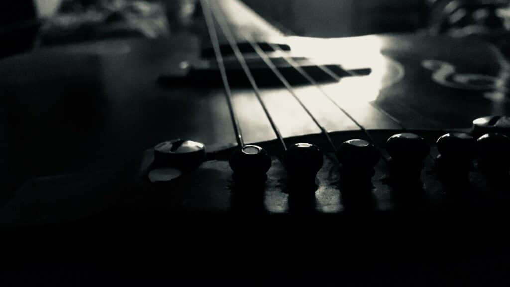 Dettaglio in bianco e nero delle corde e del ponte di una chitarra