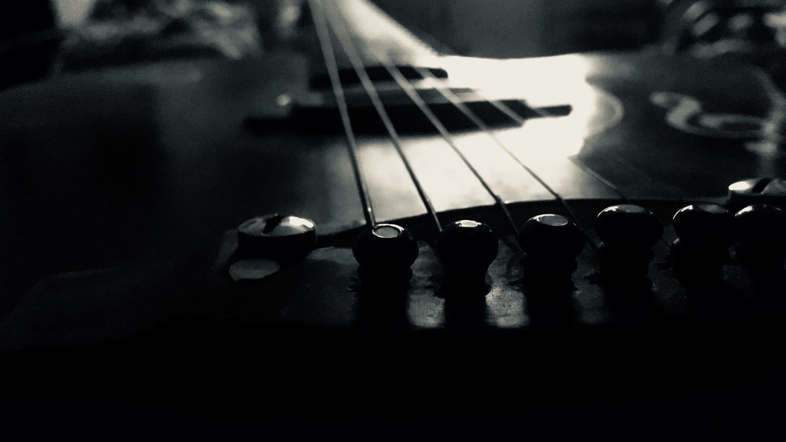 Dettaglio in bianco e nero delle corde e del ponte di una chitarra
