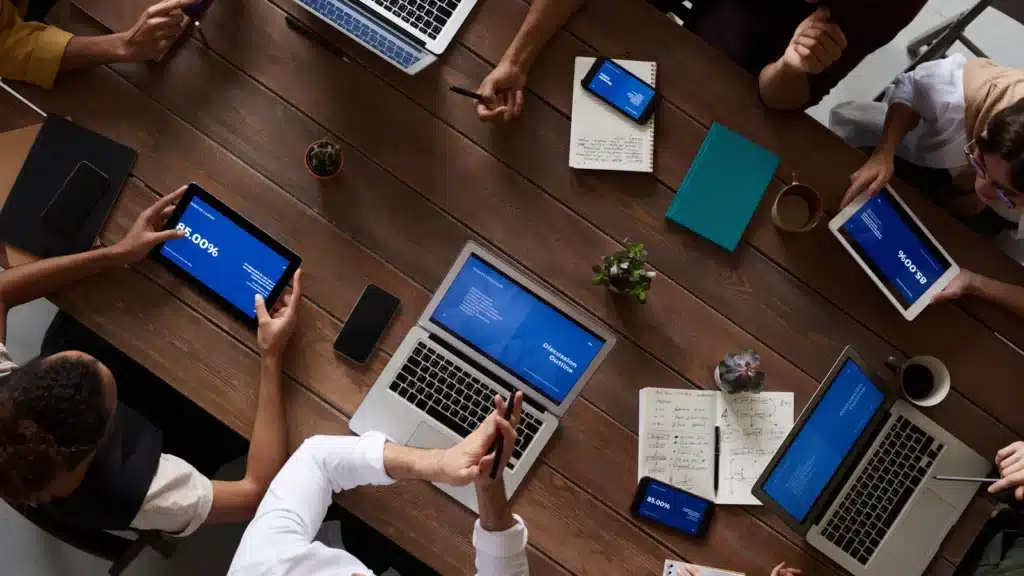 Gruppo di colleghi riuniti attorno a un tavolo con computer e documenti