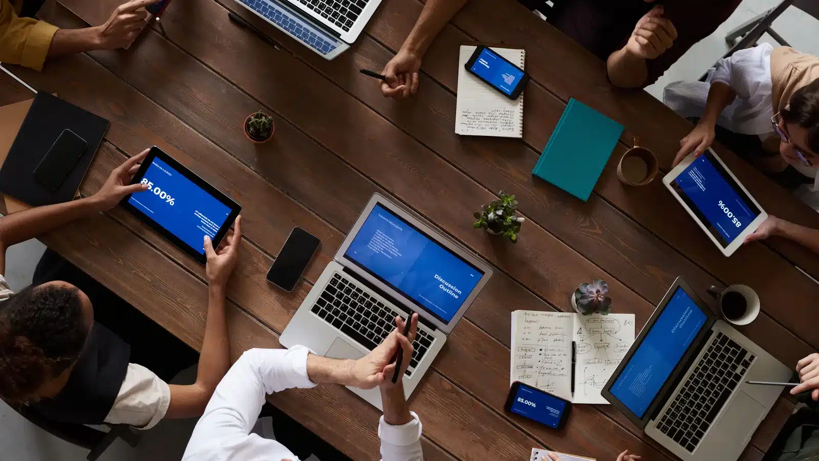 Gruppo di colleghi riuniti attorno a un tavolo con computer e documenti