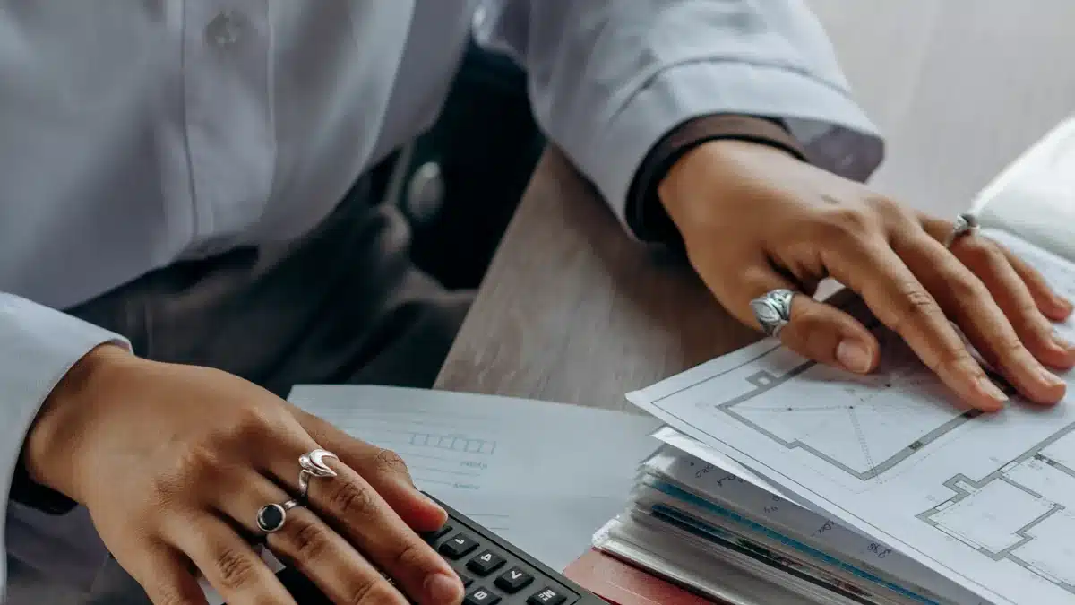 Mani al lavoro su documenti contabili con una calcolatrice
