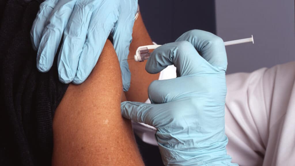 Operatore sanitario somministra il vaccino antinfluenzale a un paziente